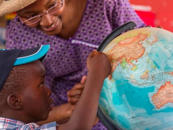 child looking at a globe