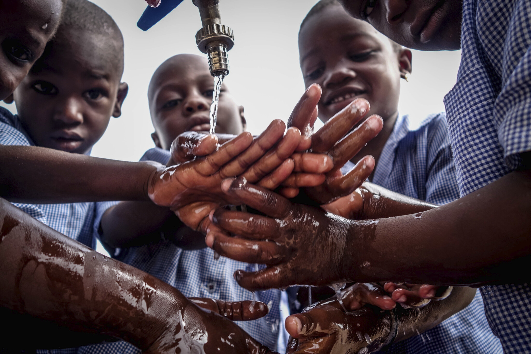 Boys washing hands under outdoor faucet, Jake Meyers, Peace Corps Benin